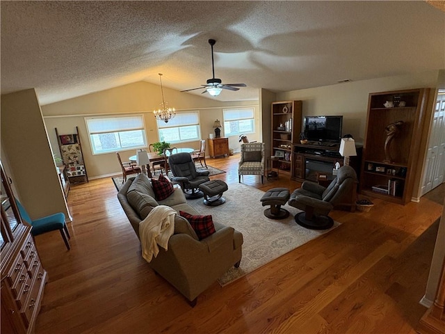 living room with vaulted ceiling, a textured ceiling, ceiling fan with notable chandelier, and hardwood / wood-style floors