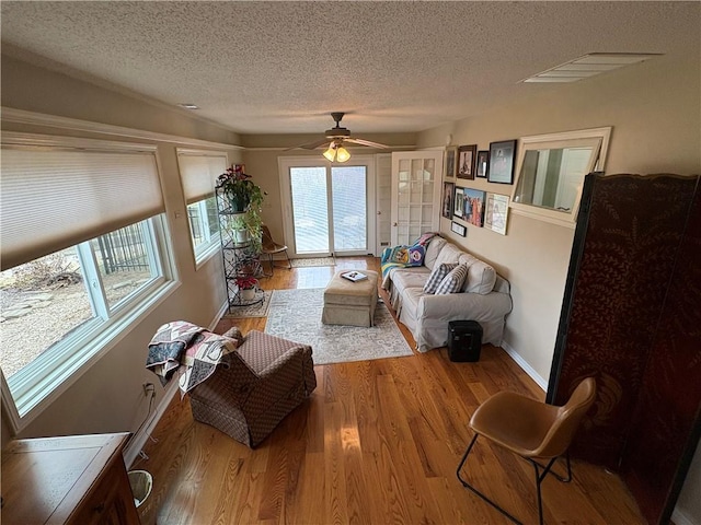 living room featuring plenty of natural light, wood-type flooring, and a textured ceiling