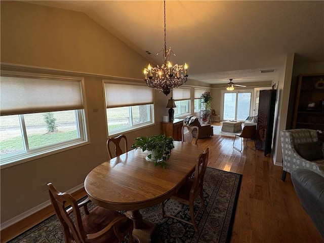 dining area featuring hardwood / wood-style flooring, lofted ceiling, and ceiling fan with notable chandelier