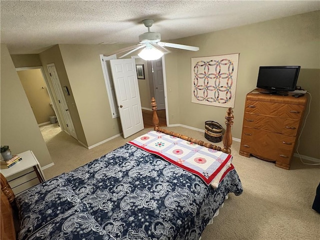 carpeted bedroom featuring ceiling fan and a textured ceiling