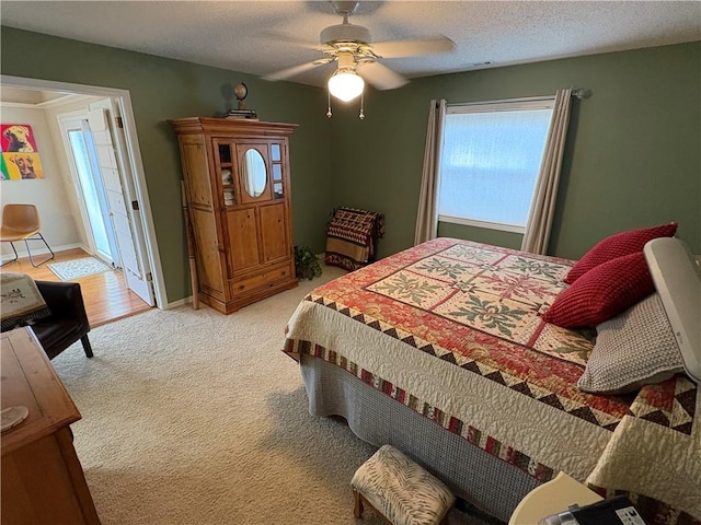 carpeted bedroom featuring ceiling fan and a textured ceiling