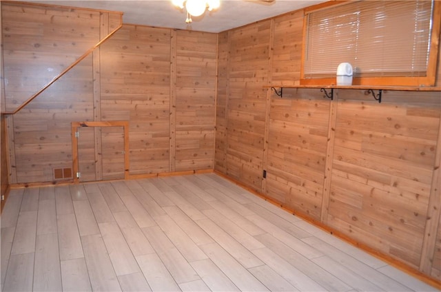 additional living space featuring light wood-style flooring, wooden walls, and a sauna