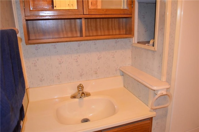 bathroom with vanity and wallpapered walls