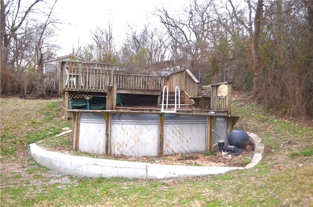 rear view of property with an outdoor pool and a wooden deck