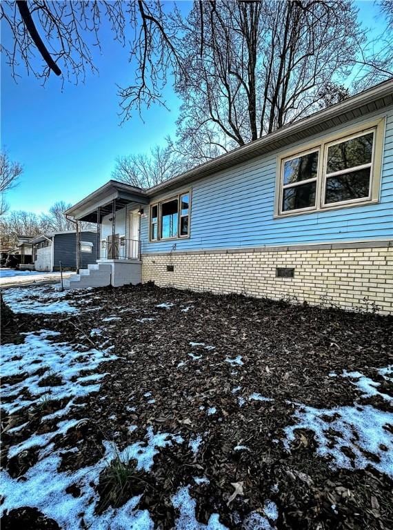 view of snowy exterior featuring covered porch