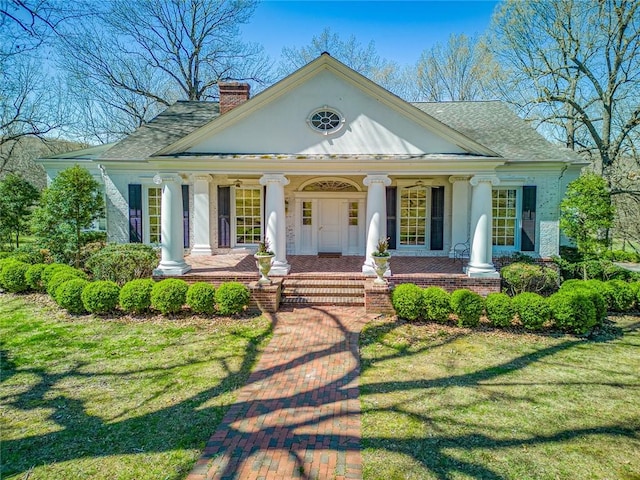 greek revival house featuring a front yard