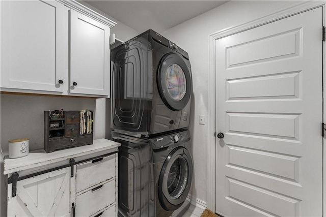 washroom with stacked washer / dryer and cabinets