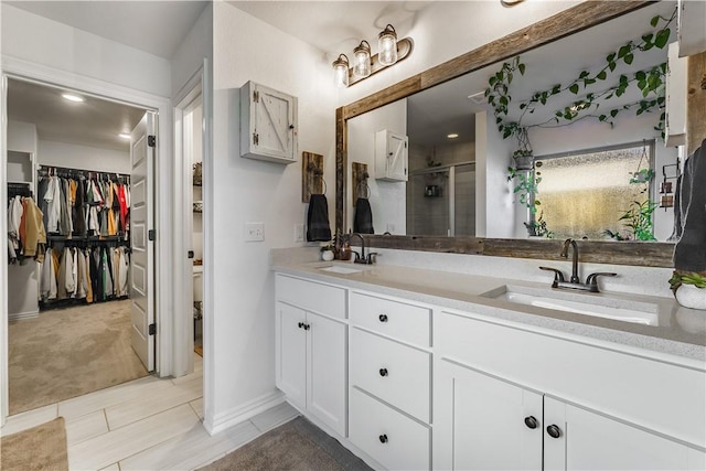 bathroom featuring a shower with shower door, vanity, and tile patterned flooring