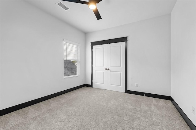 unfurnished bedroom with light carpet and ceiling fan