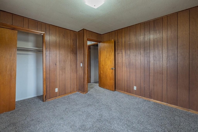 unfurnished bedroom with a textured ceiling, a closet, and light colored carpet