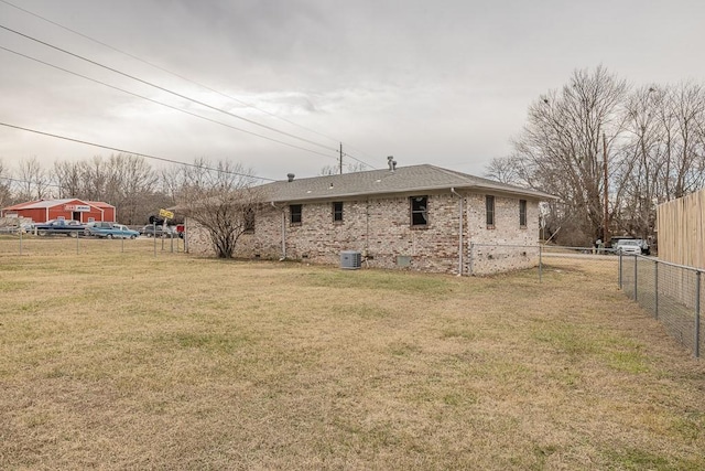 rear view of property featuring a yard and central air condition unit