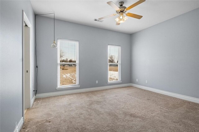 carpeted spare room with ceiling fan and a wealth of natural light