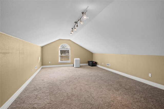 bonus room with lofted ceiling and carpet floors