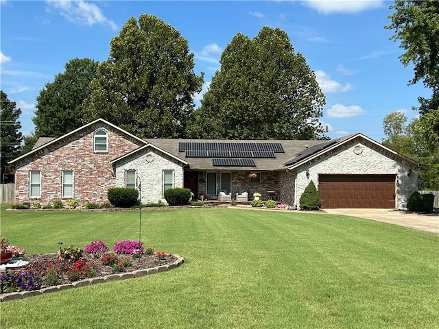 single story home with a front yard, a garage, and solar panels