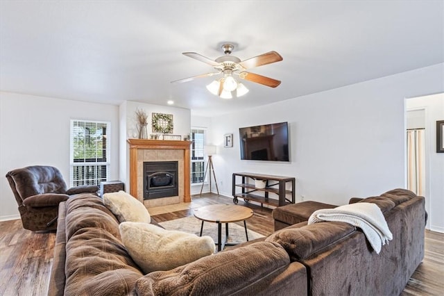 living room with ceiling fan, a fireplace, and hardwood / wood-style flooring