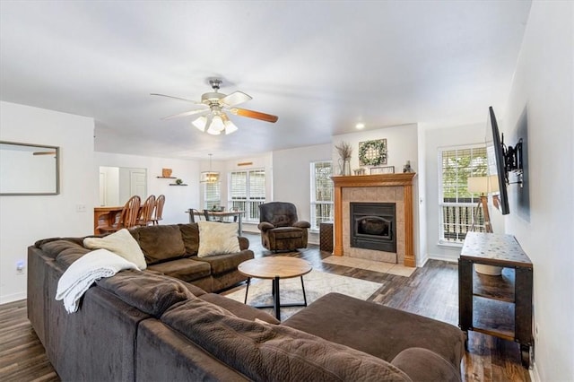 living room with ceiling fan, dark wood-type flooring, and a fireplace