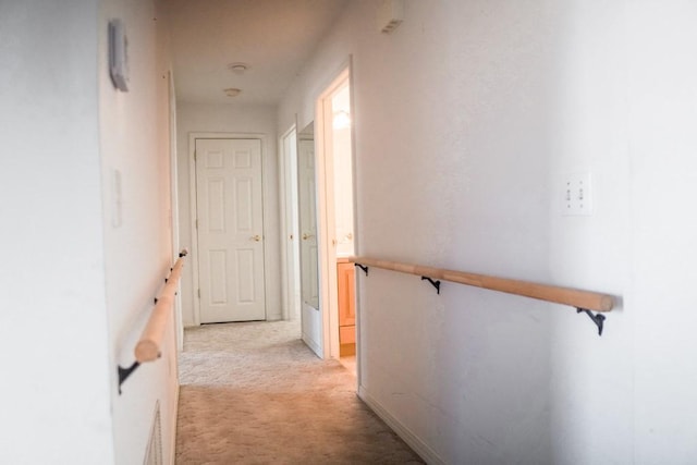 hallway featuring light colored carpet