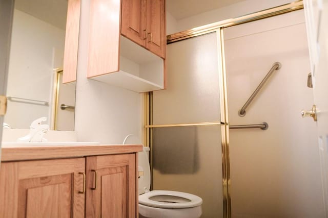 bathroom featuring vanity, an enclosed shower, and toilet