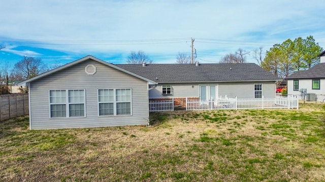 rear view of house featuring a yard and central AC