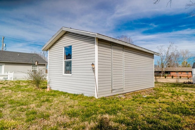 view of home's exterior featuring a lawn and a storage unit