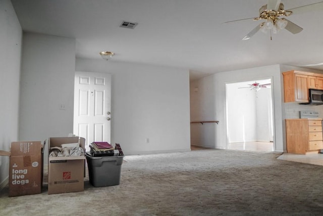 unfurnished living room featuring light carpet and ceiling fan