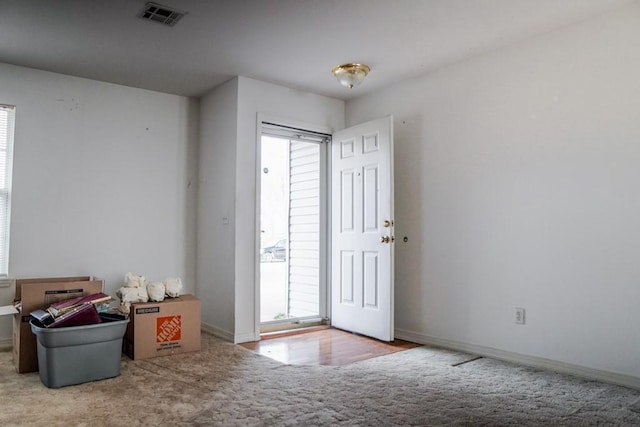 foyer entrance featuring plenty of natural light and light carpet