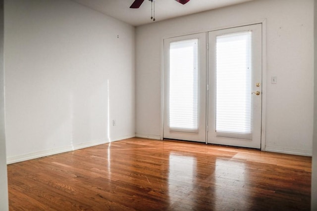 unfurnished room with hardwood / wood-style flooring, ceiling fan, and french doors