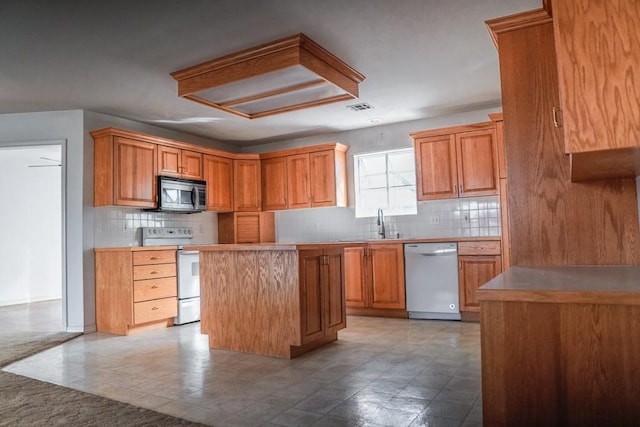 kitchen featuring sink, backsplash, stainless steel appliances, and a center island