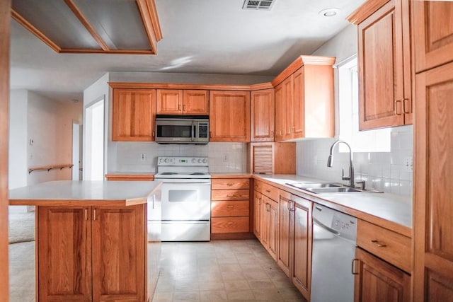 kitchen featuring sink, decorative backsplash, a kitchen island, and appliances with stainless steel finishes