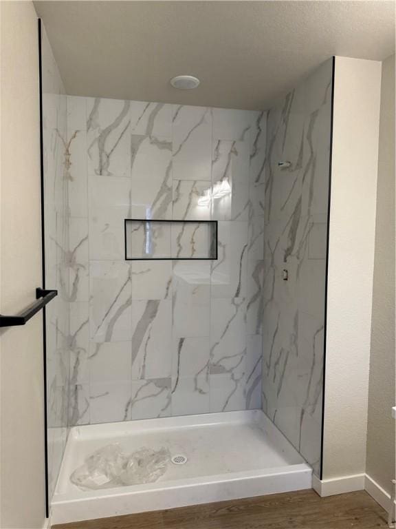 bathroom with hardwood / wood-style floors and tiled shower