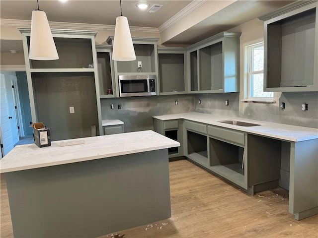 kitchen featuring backsplash, pendant lighting, gray cabinets, and crown molding