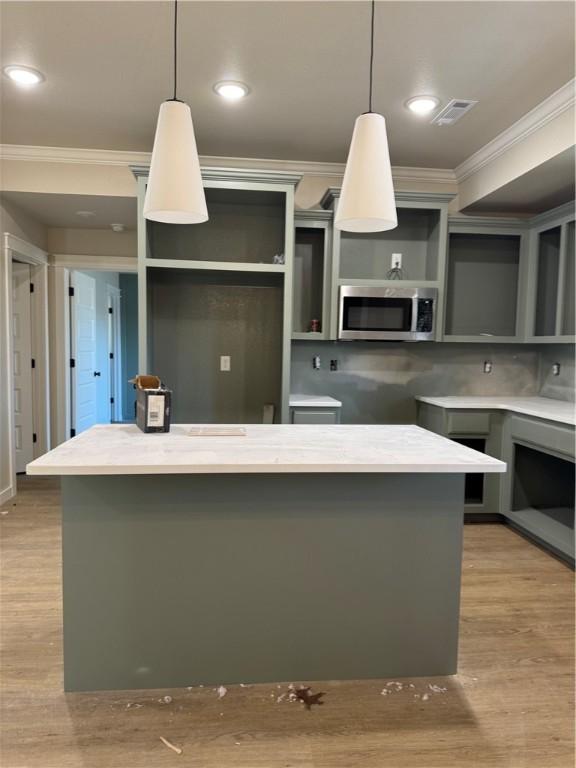 kitchen featuring ornamental molding, hanging light fixtures, and a center island