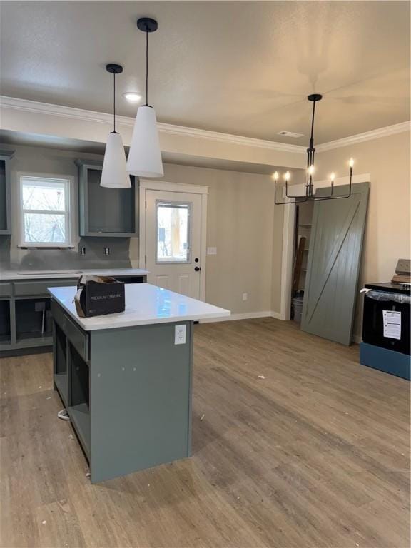 kitchen featuring plenty of natural light, hanging light fixtures, a center island, and a barn door