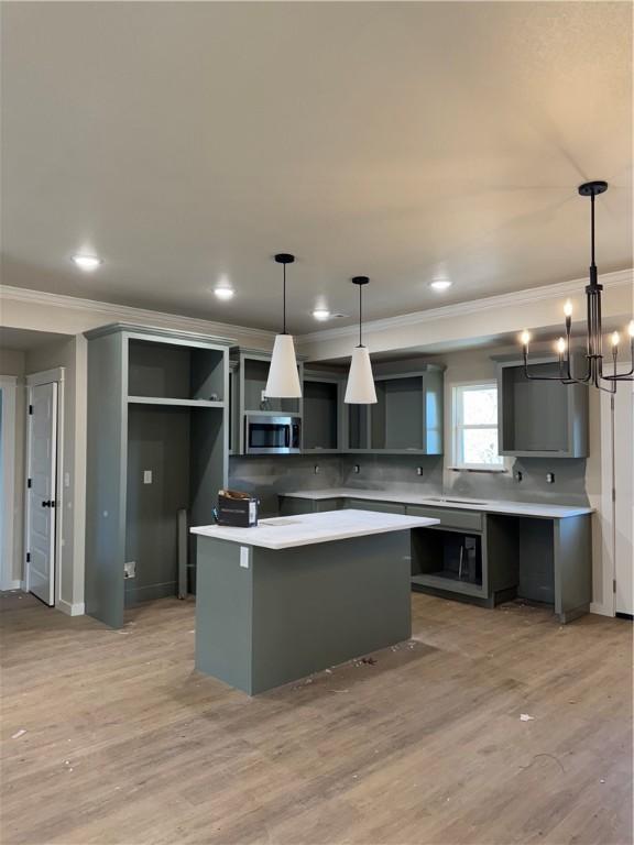 kitchen with tasteful backsplash, light hardwood / wood-style flooring, pendant lighting, and a kitchen island