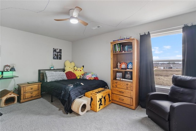 carpeted bedroom with visible vents and a ceiling fan