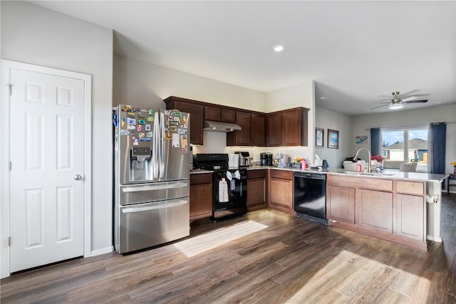 kitchen with under cabinet range hood, a peninsula, wood finished floors, a sink, and black appliances