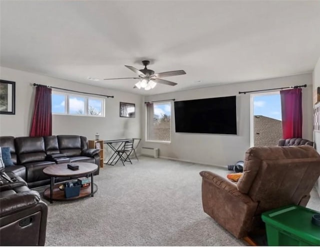 carpeted living area featuring a ceiling fan and a baseboard radiator