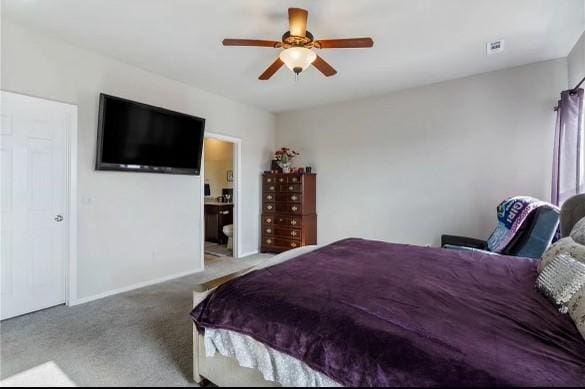 carpeted bedroom featuring a ceiling fan, visible vents, ensuite bath, and baseboards