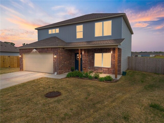 traditional-style home with fence, a front lawn, an attached garage, driveway, and brick siding