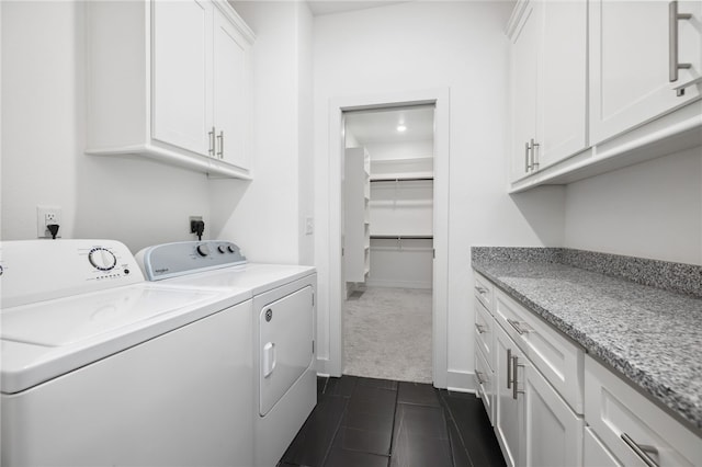 washroom featuring washing machine and dryer, cabinets, and dark colored carpet