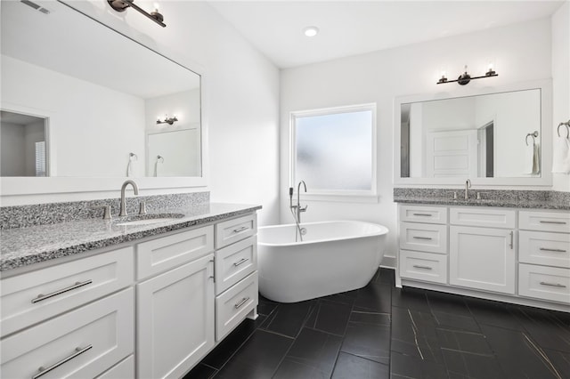 bathroom featuring vanity, tile patterned flooring, and a washtub