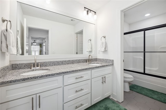 full bathroom featuring toilet, vanity, tile patterned flooring, ceiling fan, and combined bath / shower with glass door