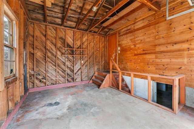 miscellaneous room with wooden walls and concrete flooring