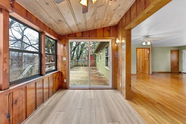 interior space featuring wooden ceiling, lofted ceiling, light hardwood / wood-style floors, and wooden walls