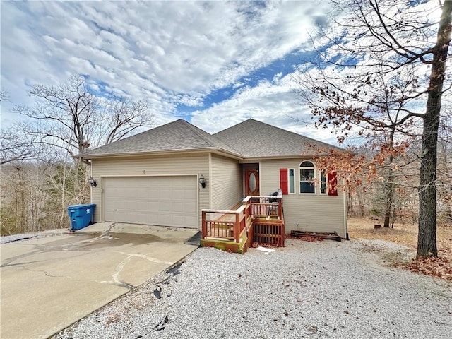 view of front of house featuring a garage, driveway, and a shingled roof