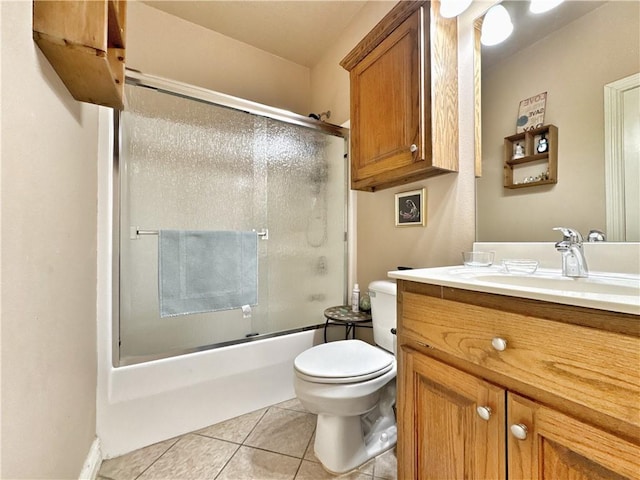 bathroom with shower / bath combination with glass door, vanity, toilet, and tile patterned floors