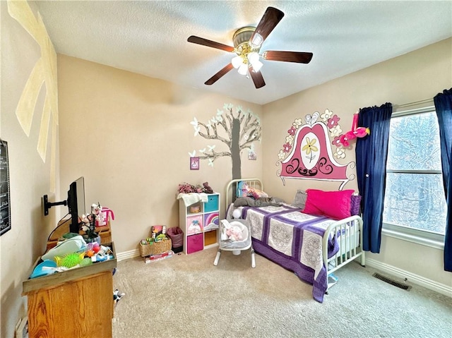 carpeted bedroom with a ceiling fan, baseboards, visible vents, and a textured ceiling