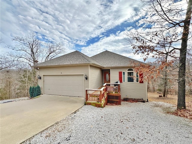 view of front of property featuring concrete driveway, roof with shingles, and an attached garage