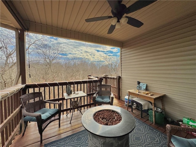 wooden deck featuring ceiling fan and a fire pit