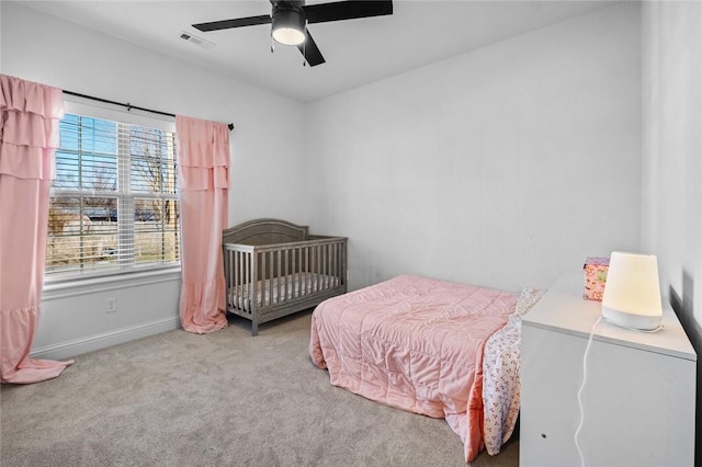 carpeted bedroom featuring ceiling fan and multiple windows